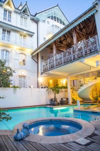 a hotel with a swimming pool in front of a building at Le Juliette Dodu in Saint-Denis