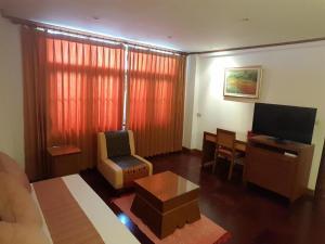 a living room with a couch and a television at Dusit Hotel in Sakon Nakhon