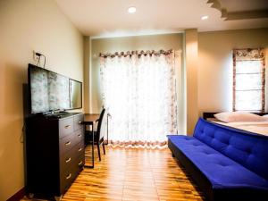 a bedroom with a blue couch in front of a window at Baan Pran Boutique Resort in Hua Hin