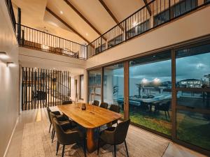 Un comedor con mesa y sillas de madera. en Sonvanger Villa Oceanfront Luxury, en Struisbaai