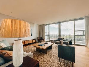 una sala de estar con un sofá y una mesa en Sonvanger Villa Oceanfront Luxury, en Struisbaai