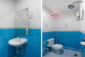 a blue and white bathroom with a toilet and a sink at OYO 577 For Love Hotel in Samut Sakhon