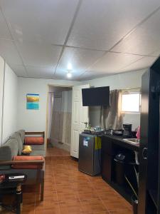a living room with a couch and a kitchen at Cuarto estudio HERSOR in San Salvador