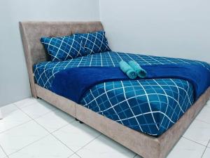 a bed with a blue comforter and pillows at CMS Simple Stay Alor Setar in Alor Setar