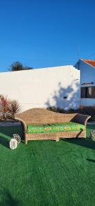 a wicker couch sitting on a lawn in a yard at Casa Vitorino in Leiria