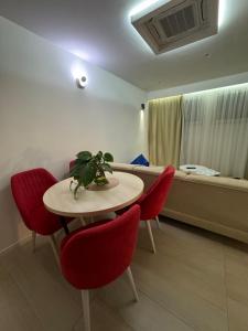 Zimmer mit einem Tisch mit roten Stühlen und einem Sofa in der Unterkunft The pearl residence Sarajevo - Bascarsi - Walk everywhere in Sarajevo