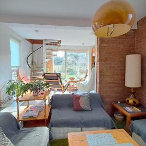Una sala de estar con un sofá azul y sillas. en Scandi inspired holiday home Brentwood, en Brentwood