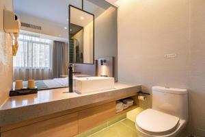 une salle de bain avec un lavabo, des toilettes et un miroir dans l'établissement GreenTree Inn Wuxi Quanshan Center, à Wuxi 126 autres photos