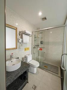 a bathroom with a toilet and a sink and a shower at GreenTree Alliance Hotel Chongqing Qianjiang County Wuling Shui'an Jiaotong Xi Road in Qianjiang