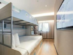 a bedroom with a bunk bed and a flat screen tv at Yitel Collection Shanghai Hongqiao Airport in Shanghai +276 photos