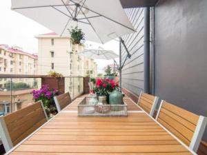 a wooden table with benches and an umbrella on a balcony at Yitel Collection Shanghai Hongqiao Airport in Shanghai