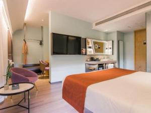 a hotel room with a large bed and a tv at Yitel Collection Shanghai Hongqiao Airport in Shanghai