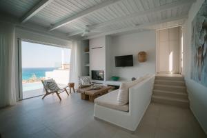 a living room with a white couch and a large window at Villa Sávra in Plakias