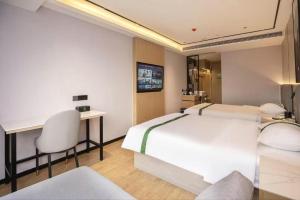 ein Schlafzimmer mit einem großen weißen Bett und einem Schreibtisch in der Unterkunft GreenTree Inn Bengbu Huaihe Walking Street in Bengbu + 207 Fotos