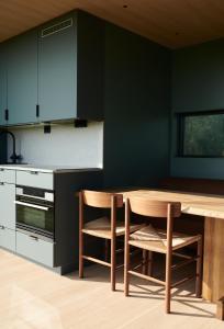 a kitchen with a wooden table and chairs at Grend Stavern in Larvik