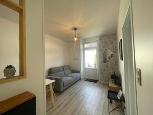 a living room with a couch and a window at Charmant T2 avec cour extérieure in Cholet