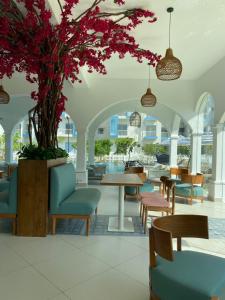 a lobby with tables and chairs and a tree at Santorini Apartments 1D F5 U8 in Negombo