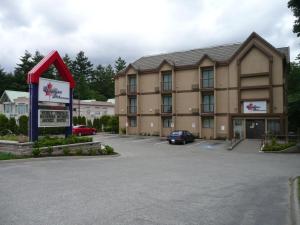 un hotel con un cartel en un estacionamiento en Canadian Inn, en Surrey