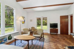 ein Wohnzimmer mit Fernseher und Tisch und Stühlen in der Unterkunft Renovated Cottage Near Forest And Beach in Rørvig