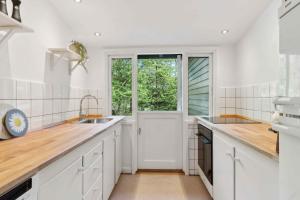 eine Küche mit weißen Schränken und einem Fenster in der Unterkunft Renovated Cottage Near Forest And Beach in Rørvig + 16 Fotos