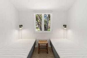 2 Betten in einem Zimmer mit einem Tisch dazwischen in der Unterkunft Renovated Cottage Near Forest And Beach in Rørvig