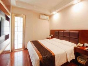 a bedroom with a large bed and a television at GreenTree Inn HeFei LongChuan Road South Hefei Railway Station Business Hotel in Hefei +106 photos