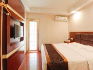 a bedroom with a bed and a flat screen tv at GreenTree Inn HeFei LongChuan Road South Hefei Railway Station Business Hotel in Hefei