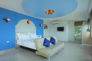 a blue bedroom with a bed and a chair at Pearl By The Sea Resort in Prachuap Khiri Khan