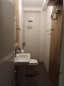 a white bathroom with a toilet and a sink at Riverside Bliss in Kandy