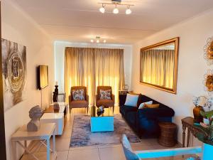 a living room with a couch and two chairs at CLASSY and COZY 4 in Fourways