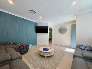 una sala de estar con un sofá y una mesa en Broadwater Beach Cottage, en Broadwater