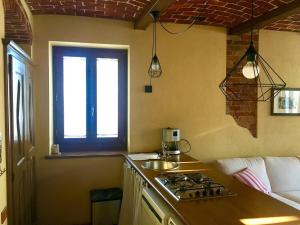 a kitchen with a stove and a sink and a window at Cascina Sant'Anna in Arignano