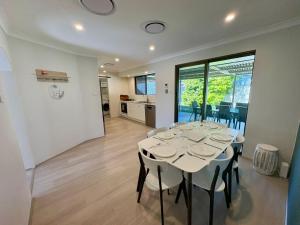 Un comedor con una mesa y sillas blancas. en Broadwater Beach Cottage, en Broadwater