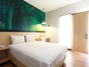 een slaapkamer met een groot bed met een groot schilderij aan de muur bij Kingstone Hotel in Kranggan-wetan Satu +57 foto's
