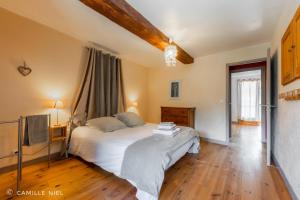 una camera da letto con un letto bianco e una televisione di la Tarte Qui Flette a Saint-Sulpice