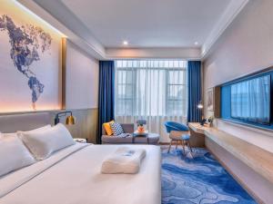 una camera d'albergo con un letto grande e una TV di Kyriad Marvelous Hotel·Yanbu International Tea City a Canton
