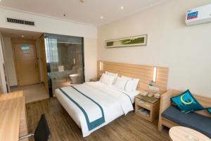 a bedroom with a large bed and a couch at City Comfort Inn Ezhou Wenxing Avenue Central Hospital in Ezhou