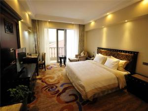a hotel room with a large bed and a desk at Shilin Yinruilin International Hotel in Lumeiyi