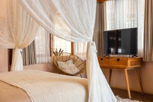 Un dormitorio con una cama y un televisor de pantalla plana. en Villa Yang Uluwatu - Central 1BDR Villa with Pool, en Uluwatu