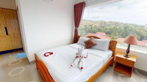 a bedroom with a bed with a large window at Damina boutique hotel in Mui Ne +71 photos