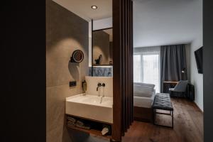 a bathroom with a sink and a bed and a mirror at Hotel Alte Post Südsteiermark in Leibnitz +40 photos
