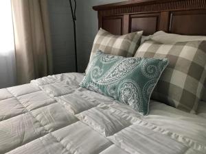 a bed with a green and white pillow on it at Keuka Lake Motel - Adults Only in Dundee
