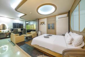 a bedroom with a white bed and a living room at Arioso Motel in Seryu-dong