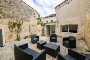 a courtyard with black chairs and tables in front of a building at La Jarnacaise #12pers #6 chambres in Jarnac