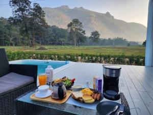 una mesa con una bandeja de comida para el desayuno. en ตลอดกาล Ta-Lord-Karn Pool Villa Chiangdao, en Ban Musoe