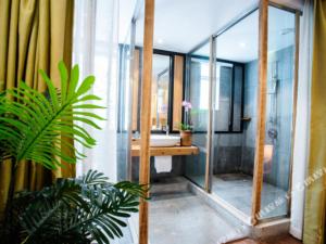 Un baño con ducha, lavabo y espejo. en Meizhou See You Again Hostel, en Meizhou