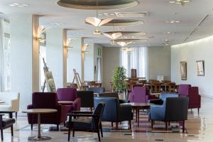 a restaurant with purple chairs and tables and tables at GARDEN HOTEL Hanayo in Tanabe