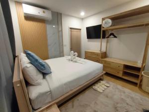 Un dormitorio con una cama grande y un televisor. en ตลอดกาล Ta-Lord-Karn Pool Villa Chiangdao, en Ban Musoe