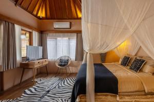 1 dormitorio con cama con dosel y TV en Villa Yin Uluwatu - Central 1BDR Villa with Pool, en Uluwatu 12 fotos más