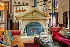 a living room with a fireplace and a red couch at Evermoore Castle Bellingen in Gleniffer